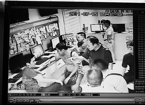 江西貴溪公安局警察在寧波發(fā)帖小伙工作店里溝通時(shí)的監(jiān)控錄像截屏。