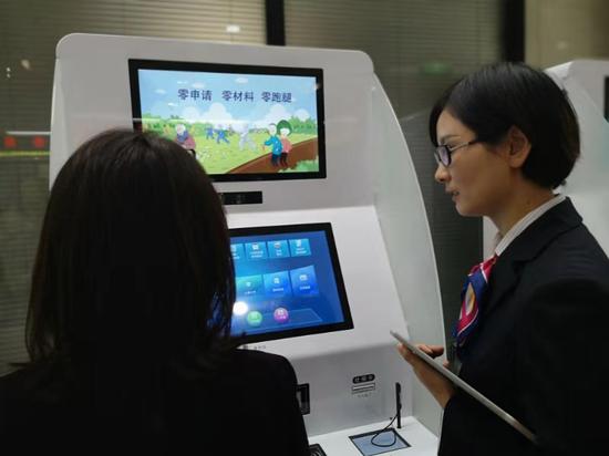 工作人員指導(dǎo)市民使用自助服務(wù)機。浙江省人社廳供圖