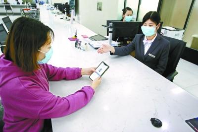  在東城區(qū)政務(wù)服務(wù)大廳，前來辦事的企業(yè)工作人員通過“北京通”授權(quán)電子證照應(yīng)用